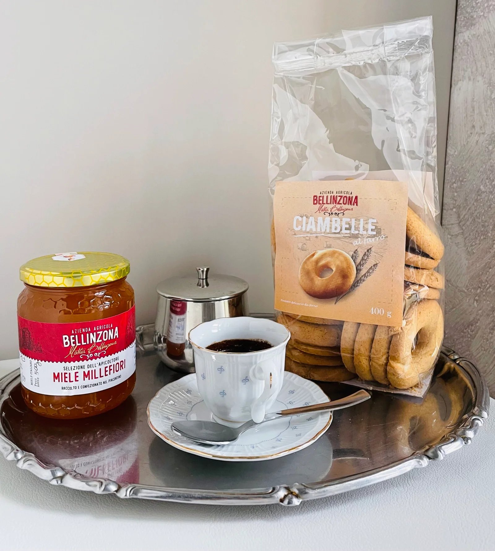 Un vasetto di miele accanto a ciambelle e un caffè